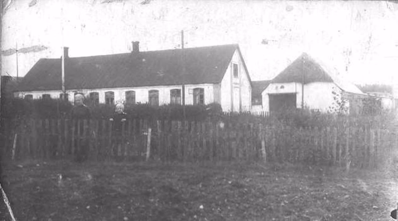 Bjørnholt-gården fotograferet tidligt i 1900-tallet - den lange længe med de mange små vinduer og det tilstødende stuehus, set fra haveside